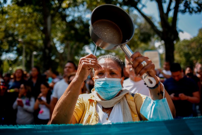 A protester bangs a saucepan during a demonstration in Caracas in January by teachers, civil servants and pensioners demanding a better income