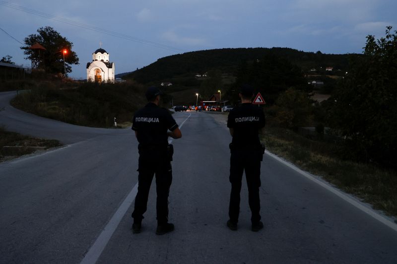 © Reuters. Police officers stand guard as protestors partially block the road near the main Kosovo-Serbia border crossing in Merdare, Serbia September 6, 2024. REUTERS/Valdrin Xhemaj