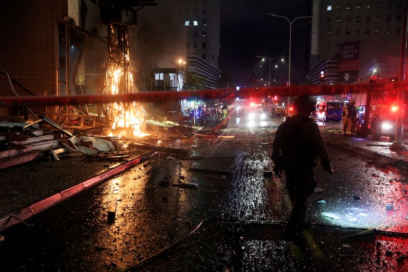 © Reuters. Security and rescue personel work at the scene where a bus and buildings were hit following a rocket attack from Lebanon towards Israel in Ramat Gan in central Israel November 18, 2024. REUTERS/ Itai Ron