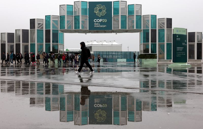 © Reuters. People walk at the entrance of the venue of the United Nations climate change conference COP29, in Baku, Azerbaijan November 18, 2024. REUTERS/Murad Sezer