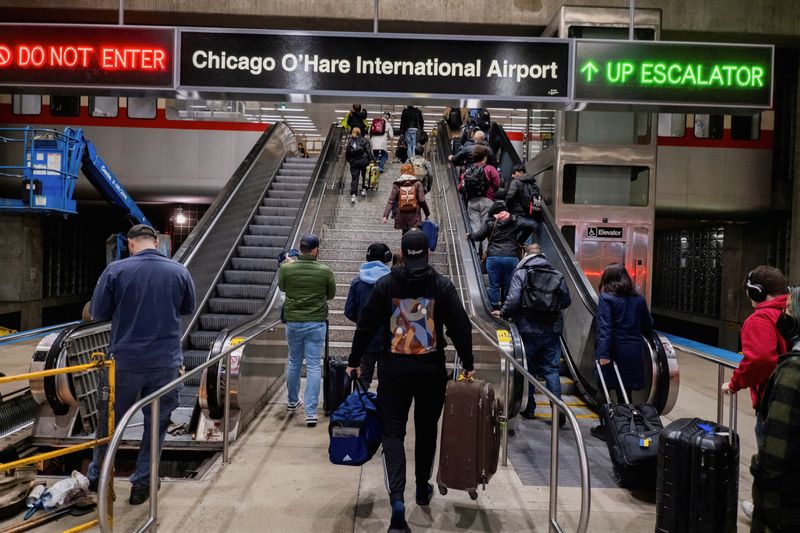 © Reuters. FILE PHOTO: People walk through the O?Hare train station, as they travel for the Thanksgiving holiday at O?Hare International Airport in Chicago, Illinois, U.S. November 22, 2023.  REUTERS/Vincent Alban/File Photo